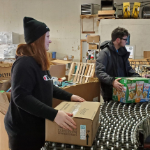 Alivia and Tucker rolling finished boxes down the line.